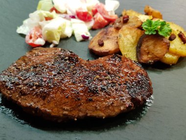 Kızartma tavasından taze kızarmış biftek ve lezzetli malzemeler.