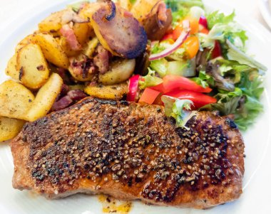 Kızartma tavasından taze kızarmış biftek ve lezzetli malzemeler.