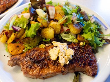 Kızartma tavasından taze kızarmış biftek ve lezzetli malzemeler.