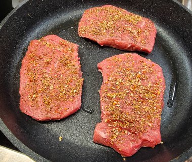 Kızartma tavasından taze kızarmış biftek ve lezzetli malzemeler.