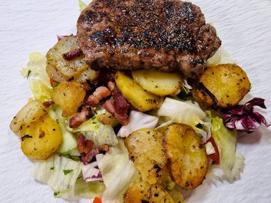 Kızartma tavasından taze kızarmış biftek ve lezzetli malzemeler.