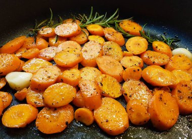 sliced root vegetables and garlic in a frying pan