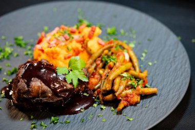 Tatlı patates püresiyle dana yanakları ve domates soslu fasulye ve sarımsaklı pastırma.