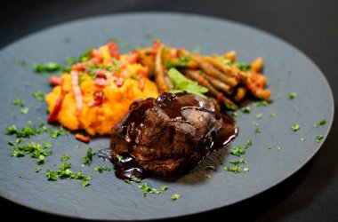 Tatlı patates püresiyle dana yanakları ve domates soslu fasulye ve sarımsaklı pastırma.