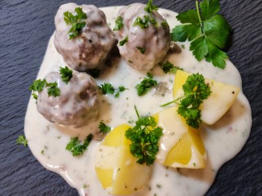 Koenigsberger Klopse köftesi ve yabanmersini soslu patates geleneksel Alman mutfağı.