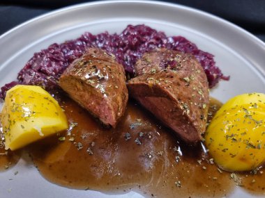 Kızarmış ördek, kırmızı lahana ve patates.