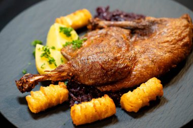 Kızarmış ördek, kırmızı lahana ve patates.