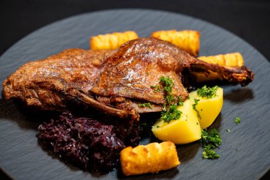 Kızarmış ördek, kırmızı lahana ve patates.
