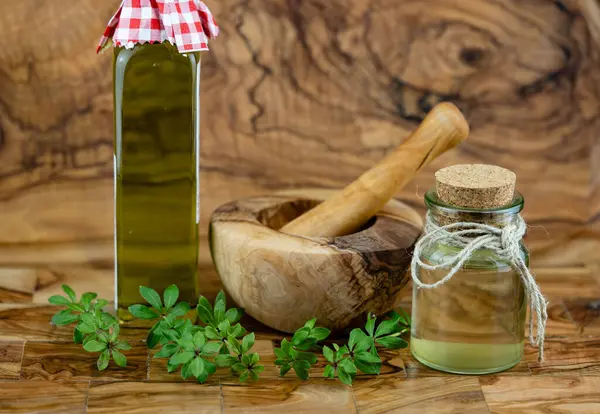 stock image green Woodruff vinegar on olive wood