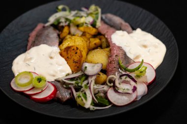 Kızarmış patates ve Sylt soslu taze sebze matjeleri.