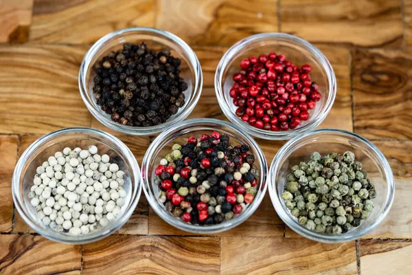 stock image a stack of peppercorns on olive wood