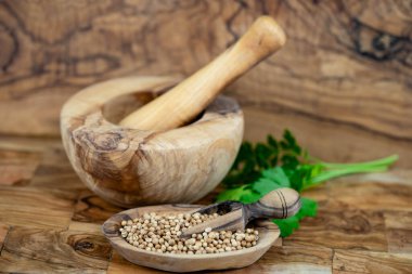 Seeds of coriander Coriandrum sativum on olive wood clipart