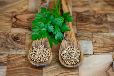 Seeds of coriander Coriandrum sativum on olive wood clipart