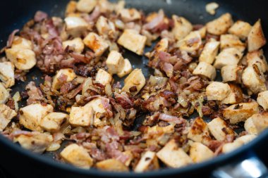 Domuz pastırması ve soğanlı kızarmış patates.