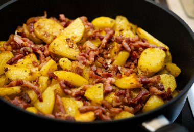 Domuz pastırması ve soğanlı kızarmış patates.