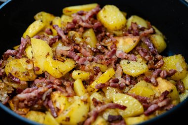 Domuz pastırması ve soğanlı kızarmış patates.