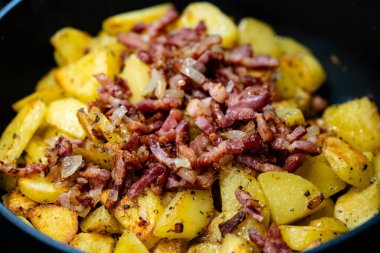 Domuz pastırması ve soğanlı kızarmış patates.