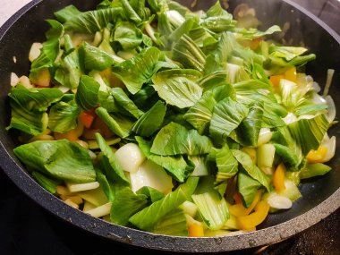 Sebzeler ve baharatlar kızartma tavasında.