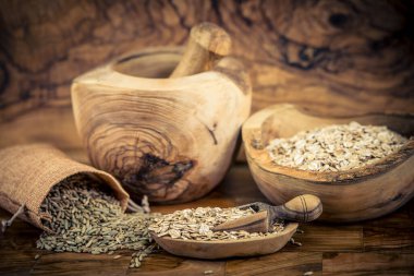 whole grain Secale cereale rye flakes on olive wood