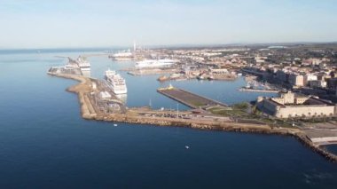 Civitavecchia şehrinin panoramik manzarası ve bitişik turizm limanı ve Forte Michelangelo. Tropik palmiye ağaçları ile zümrüt deniz ve manzara.