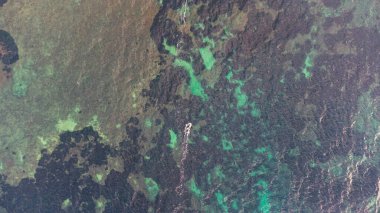 Kristal berrak Trrhenian Denizi 'nde rüzgar sörfü yapan bir adamın insansız hava aracına göz atın.