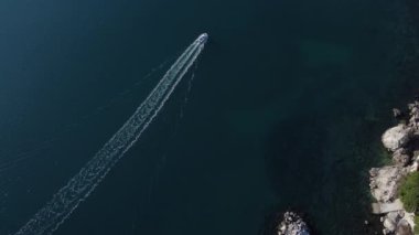 Yüzünde rüzgarla Akdeniz 'i gezen yalnız bir tekne, berrak deniz güneşli ve berrak gökyüzü.