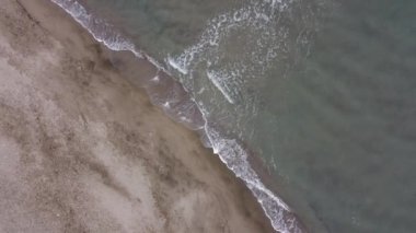 Fantastic landscape taken from the drone. Civitavecchia, Italy. Clear sea and blue sky. Waves and sand on a hot humid February day. Cloudy.