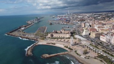 Panoramic view of the city of Civitavecchia with the adjoining tourist port and Forte Michelangelo. Emerald sea and view with tropical palm trees. Ferris wheel and cloudy sky.