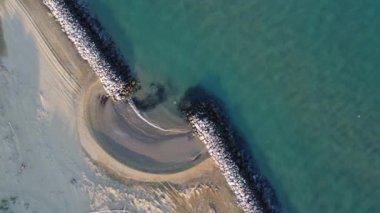 Venedik 'teki Bibione plajının hava görüntüsü. Kristal berrak su ve beyaz kayalar. Altın plaj ve dairesel şekiller. Dünya üzerindeki cennet İtalya 'da, Tagliamento nehrinin yanında..