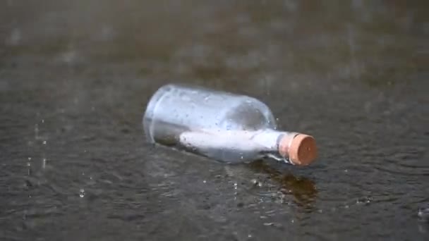 透明なガラス瓶に手紙 雨の中で海賊を助けるために呼び出します — ストック動画