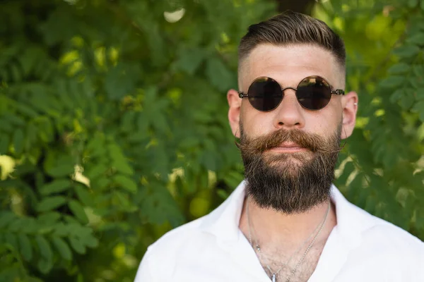 stock image Set portrait. Man smoking a cigar by the river with long beard, shirt and curled moustache.Dark glasses and authority.