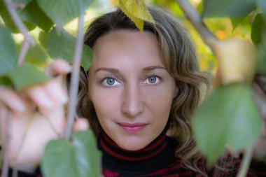 Açık havada çekim, sonbahar elbiseli sarışın kadın. Mavi gözler