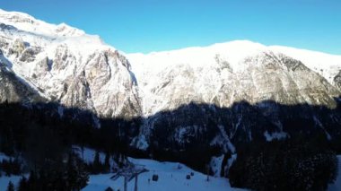 Bolzano karlı arazide insanlar kayak yapıyor. Karla kaplı dağlar