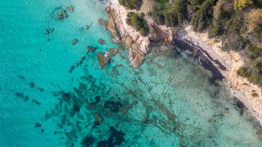 Isola Rossa ve Tramatzu sahillerindeki beyaz kum ve kristal berrak suyla Teulada limanının insansız hava aracı görüntüleri..