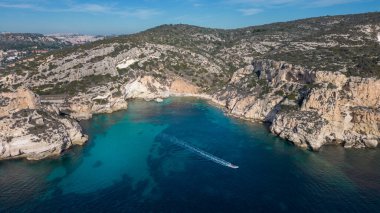 Cagliari 'deki Sella del Diavolo' nun insansız hava aracı görüntüsü. Güneşli bir gün, tekneli berrak bir deniz..