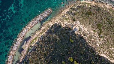 Cagliari 'deki Sella del Diavolo' nun insansız hava aracı görüntüsü. Güneşli bir gün, tekneli berrak bir deniz..