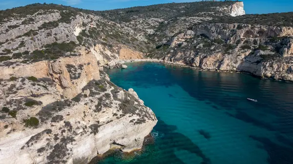 Cagliari 'deki Sella del Diavolo' nun insansız hava aracı görüntüsü. Güneşli bir gün, tekneli berrak bir deniz..