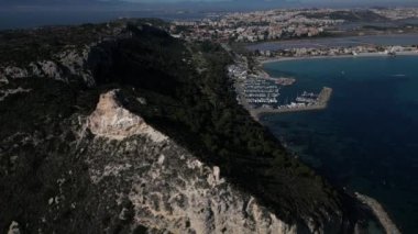 Cagliari 'deki Sella del Diavolo' nun insansız hava aracı görüntüsü. Güneşli bir gün, tekneli berrak bir deniz..