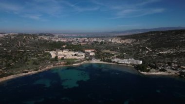 Cagliari 'deki Sella del Diavolo' nun insansız hava aracı görüntüsü. Güneşli bir gün, tekneli berrak bir deniz..