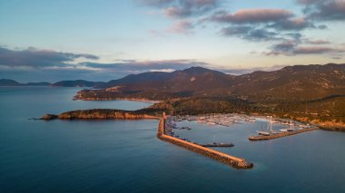 Şafakta Teulada marinası yükselen güneş ve kristal berrak deniz ile Sardunya 'da.