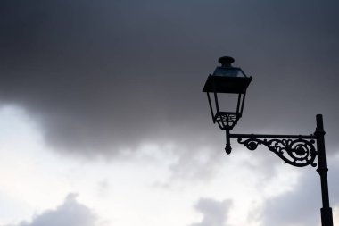 Günbatımında bulutlu arka planı olan yalnız sokak lambası