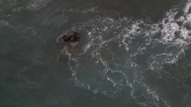 Sardinya 'da kumsalda rüzgarlı bir gün. Suyla dolu açık deniz dalgaları. Bulutlu