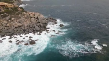 Sardinya 'da kumsalda rüzgarlı bir gün. Suyla dolu açık deniz dalgaları. Bulutlu