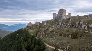 Rocca Calascio at sunset with cold light and threatening clouds clipart