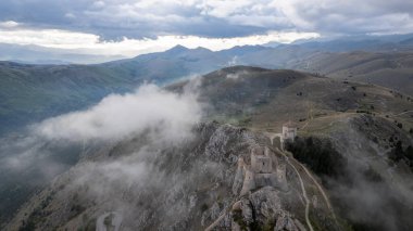 Rocca Calascio gün batımında soğuk ışık ve tehditkar bulutlarla