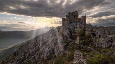 Rocca Calascio gün batımında ılık ışık ve bulutlarla