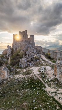 Rocca Calascio at sunset with warm light and clouds clipart