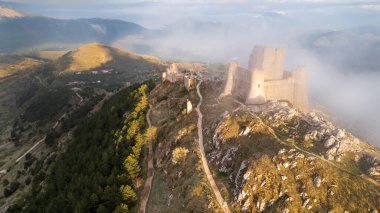 Rocca Calascio at sunset with warm light and clouds clipart