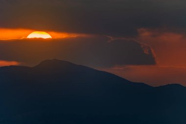 Sardunya günbatımının manzarası, bulutlardaki güneş yerine ateş topu