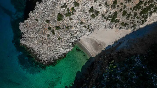 Sardinya 'daki Cala Domestica' da kristal berrak su. İlahi kayaların arasından drone atışı.